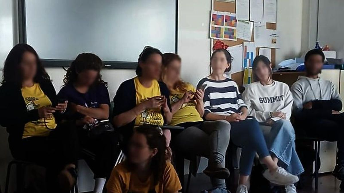 Imagen de la asamblea de docentes de Barcelona. Con camiseta de rayas blancas y azules, y con jersey gris, las dos supuestas agentes de los Mossos