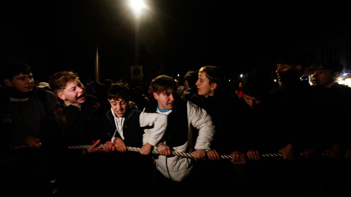 Un grupo de chavales estira de la cuerda que va atada al remolque con el que se baja el tronco desde Ternelles.