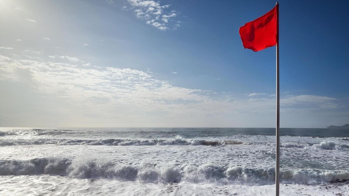 Fotografía de archivo de una bandera roja en una playa de Canarias.