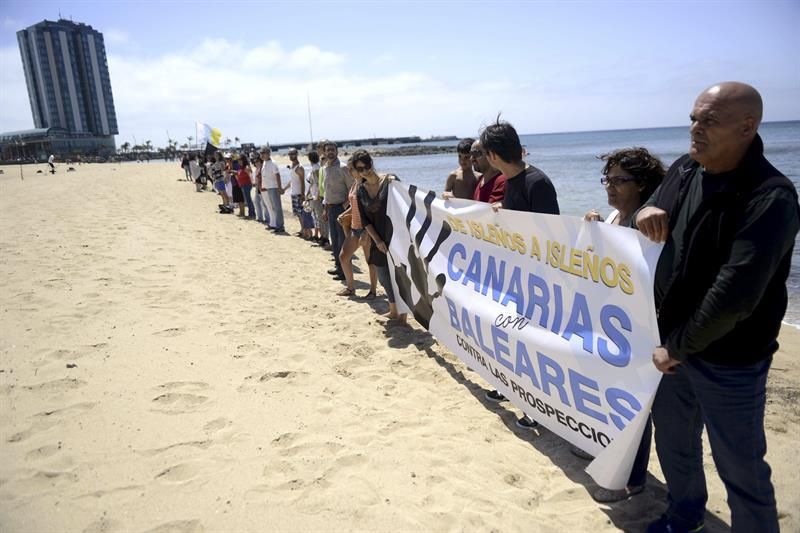 Asistentes a la cadena humana convocada en la playa de Arrecife por la Plataforma por un Nuevo Modelo Energético para manifestar su rechazo a que se autoricen prospecciones petrolíferas en aguas cercanas a Lanzarote y Fuerteventura. EFE/Javier Fuentes