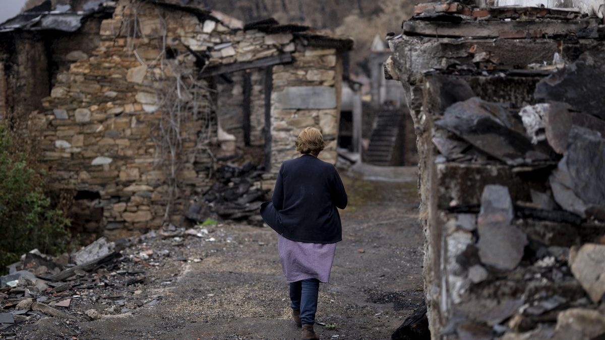 Una vecina pasea por San Vicente de Leira, en Vilamartín de Valdeorras (Ourense) tras el incendio que quemó la aldea.