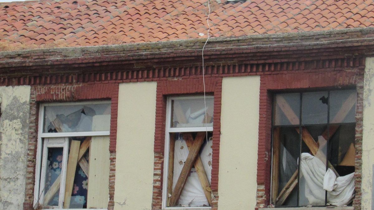 Detalle de las ventanas rotas y tapadas con colchones y planchas de madera en la planta superior del antiguo colegio Fernán Caballero