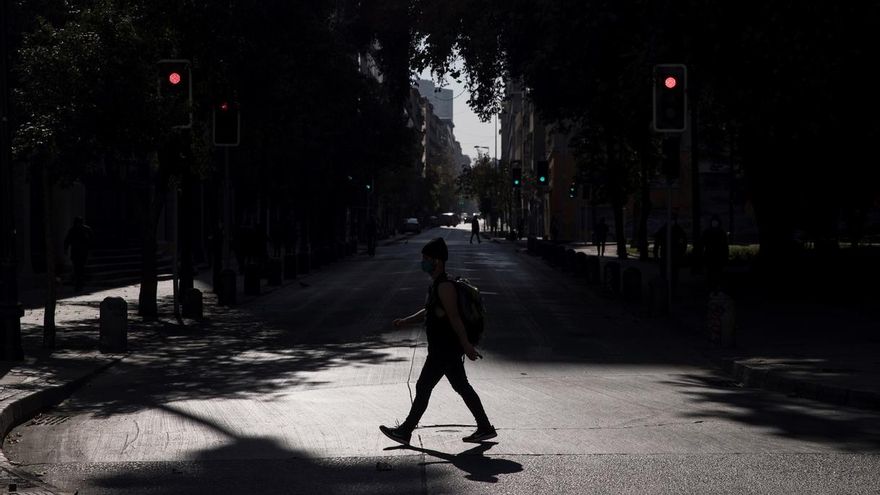 Un hombre con tapabocas es visto mientras camina por una calle semivacía en el centro de Santiago (Chile).