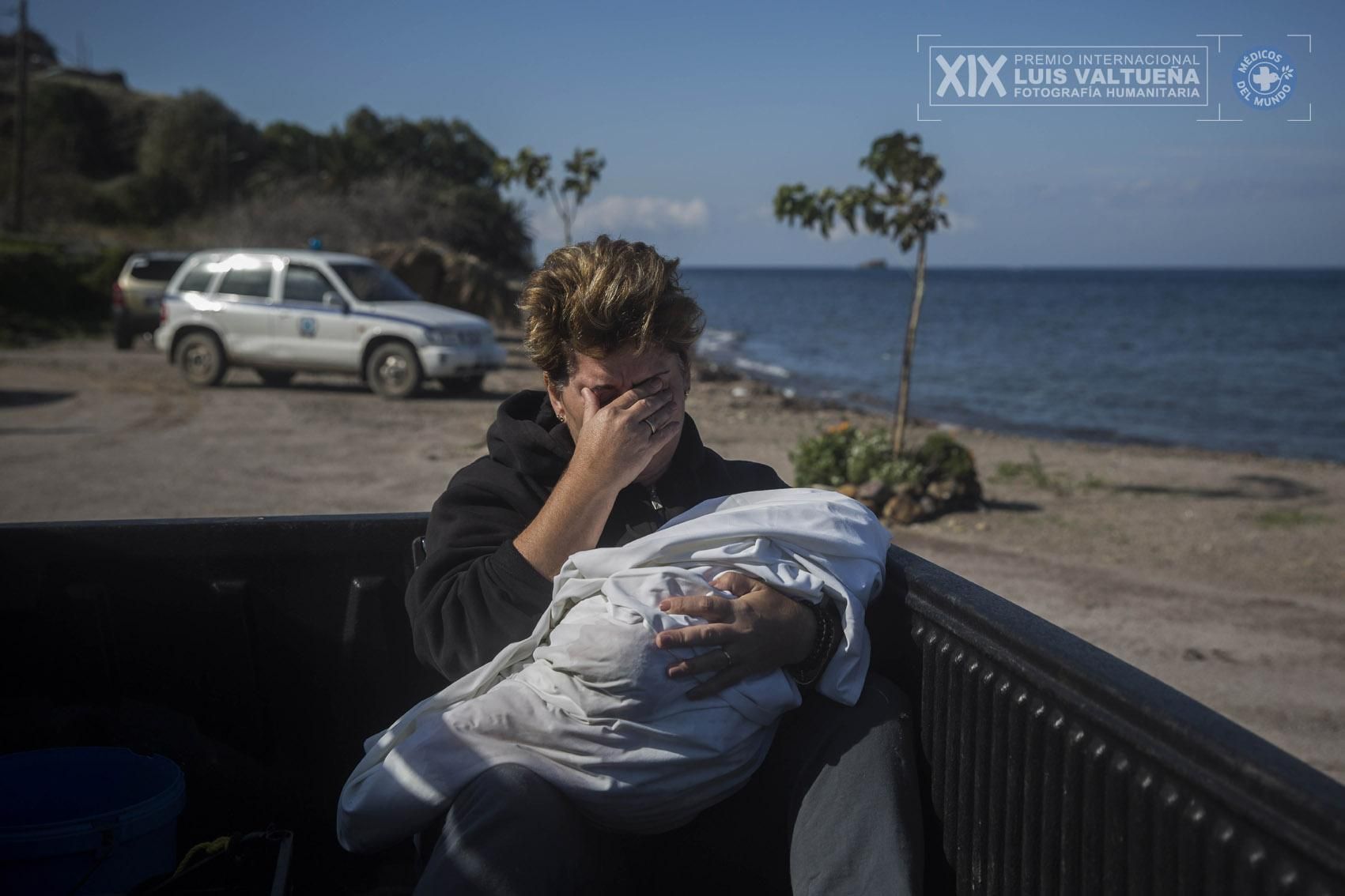 Una vecina del pueblo de Petra (Lesbos) llora con el cadáver de un bebé que apareció en las playas cercanas entre sus brazos. Muchas de las personas que han llegado por el Mediterráneo son familias con niños, la mayoría sirias, que huyen del conflicto armado que azota su país desde hace cinco años. | Foto: Santi Palacios.