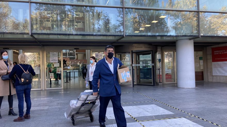 El empleado que carga en cada sesión con las maquetas de Gerardo Rueda, a su salida de la Ciudad de la Justicia.