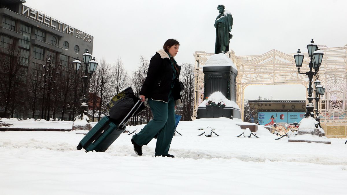 Una mujer camina por una calle cubierta de nieve frente al monumento al poeta ruso Alexander Pushkin en la plaza Pushkinskaya durante un día nevado de invierno en Moscú, el 13 de febrero de 2026.