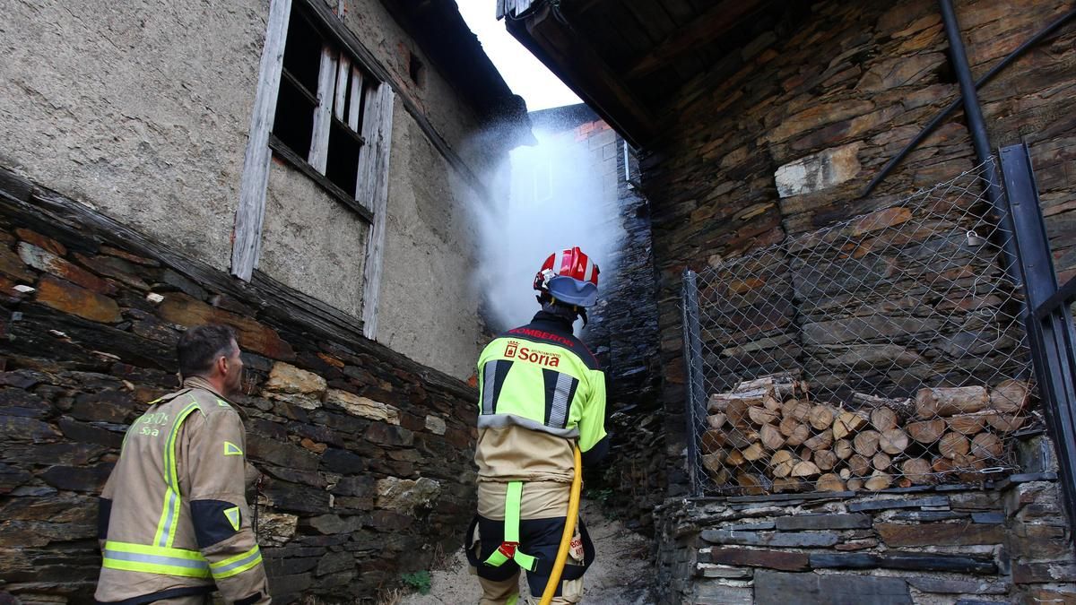 Bomberos del Ayuntamiento de Soria acuden a apagar rescoldos de casas incendiadas en el pueblo de Lusío (Oencia).