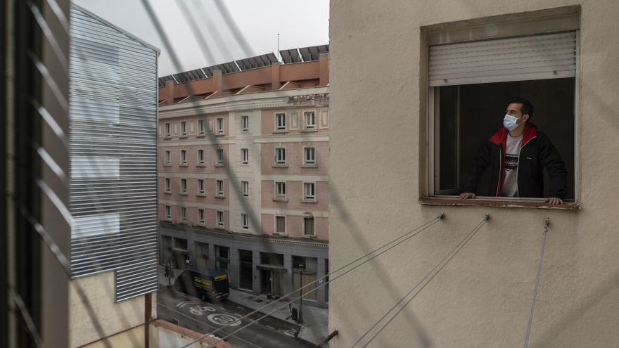 Rodrigo, asomado a una ventana de su casa, severamente afectada por la explosión de la calle Toledo. A la izquierda, el edificio que estalló recubierto con chapa.