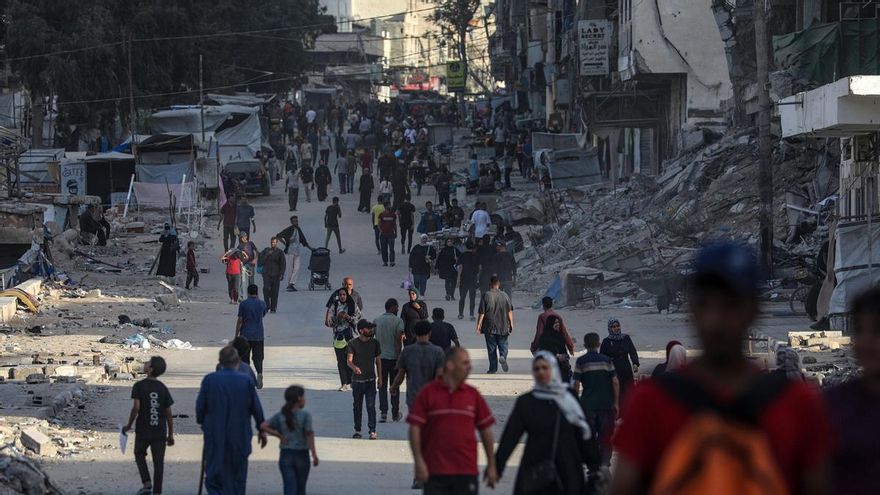Palestinos caminan por el barrio de Al Remal durante una operación israelí en la ciudad de Gaza, el dominigo.