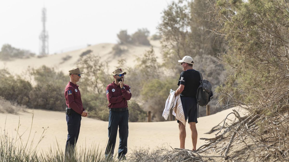 Dos agentes de Medio Ambiente dialogan con una ciudadano en las Dunas.