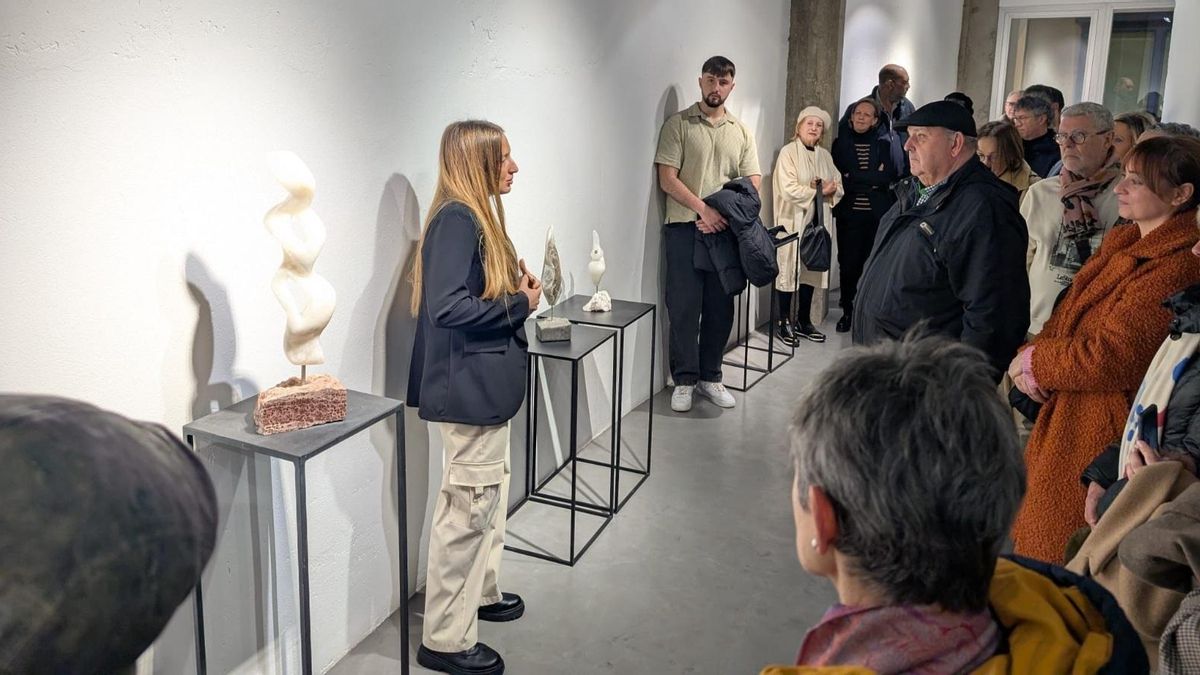 Estela Ferrer explica su obra a unos visitantes desde el taller de escultura.