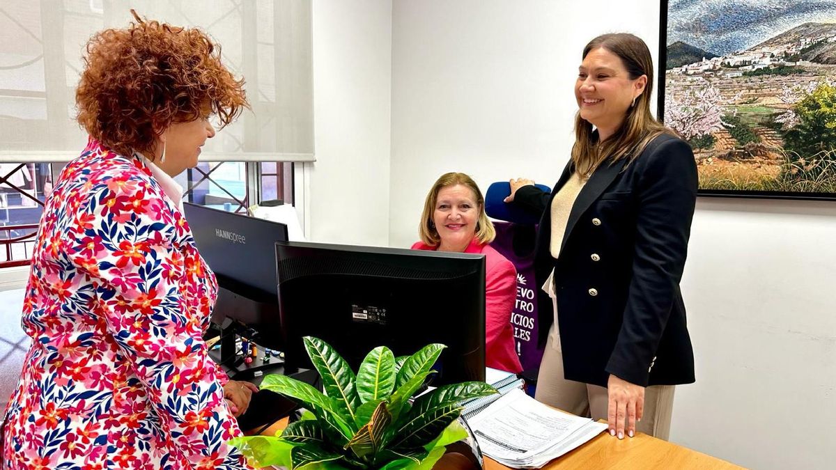 María Castillo, de pie, a la derecha, junto a dos funcionarias municipales.