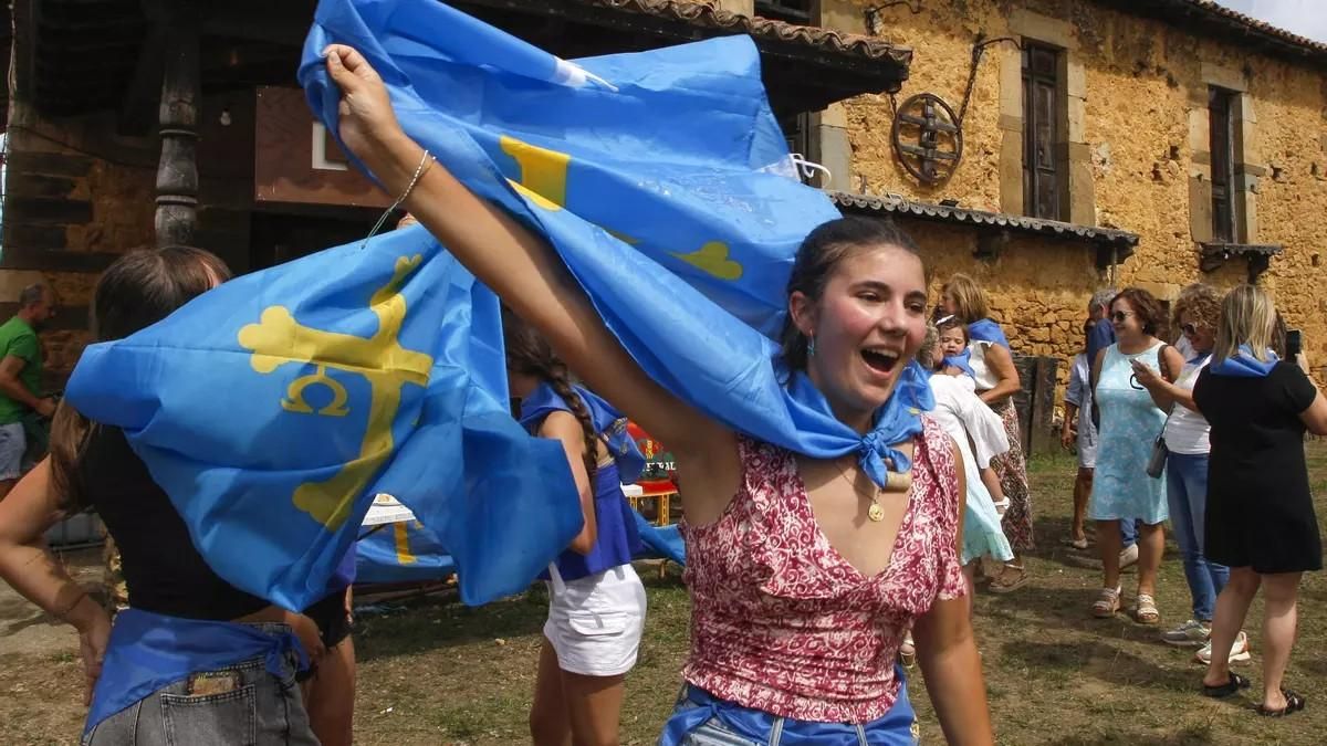 Una joven de Valdesoto celebra el galardón al Pueblo Ejemplar con una bandera de Asturias al cuello.
