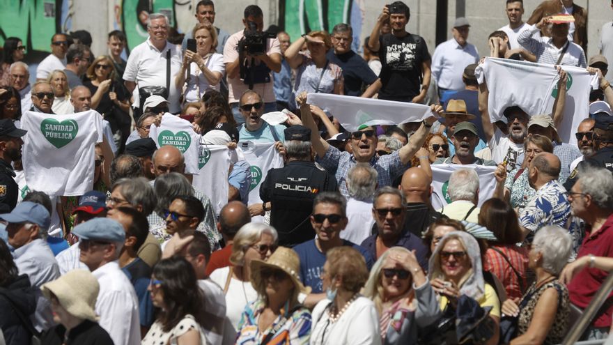 Manifestantes a favor de la sanidad publica durante el acto cívico militar por el Dos de Mayo, Día de la Comunidad de Madrid, este martes en la Puerta del Sol.