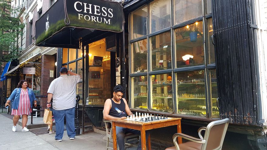 Unas personas llegan a la tienda Chess Forum donde un hombre espera frente a un tablero de ajedrez, el 20 de junio de 2021, en su local ubicado en Manhattan, Nueva York (EEUU). EFE/ Helen Cook