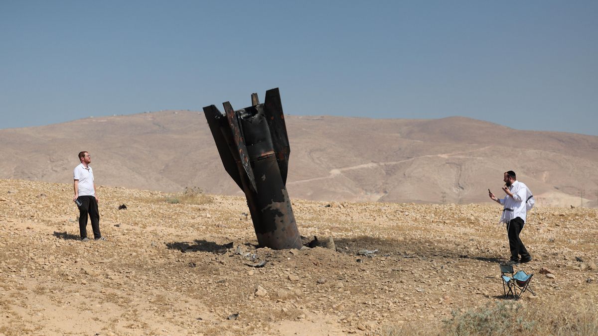 Judíos ultraortodoxos miran los restos de un misil balístico iraní que aterrizó en un campo abierto junto al asentamiento de Mevo'ot Yericho en Cisjordania, en el Valle del Jordán, este lunes.