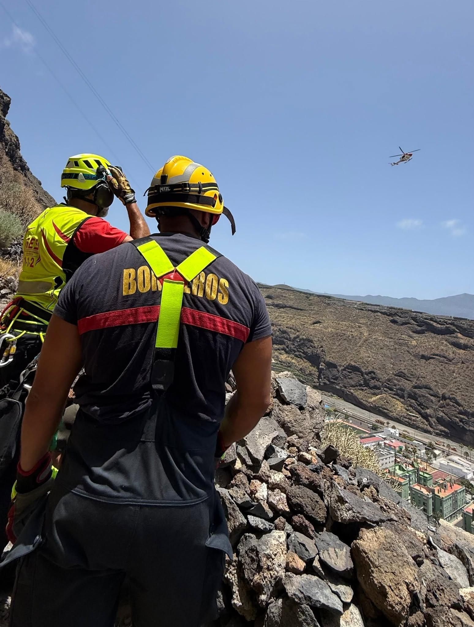 Un bombero, un técnico del 1-1-2 y  helicóptero del GES  en la zona de la bajada de El Time al Puerto de Tazacorte.
