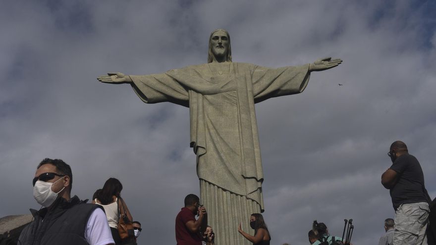 Archivo - Personas con mascarilla por el coronavirus junto al Cristo del Corcovado de Río de Janeiro