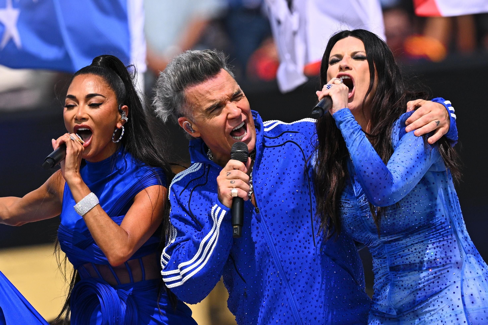 Nicole Scherzinger, Robbie Williams y Laura Pausini en la actuación anterior al partido
