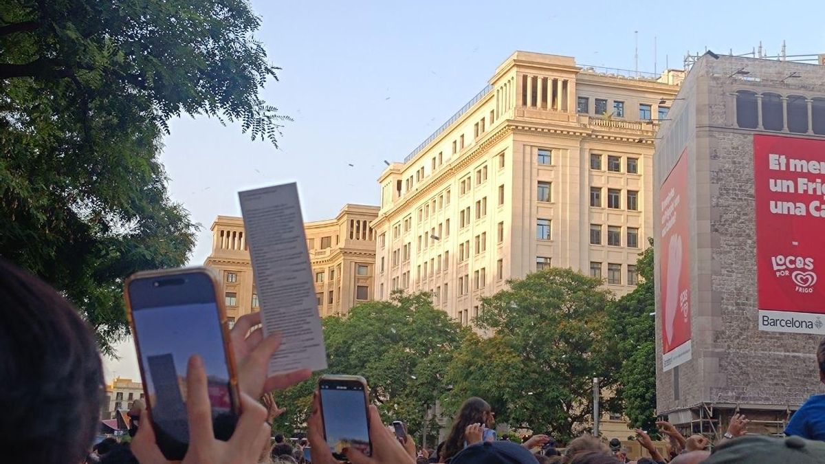Un joven sujeta un poema en el centro de Barcelona.