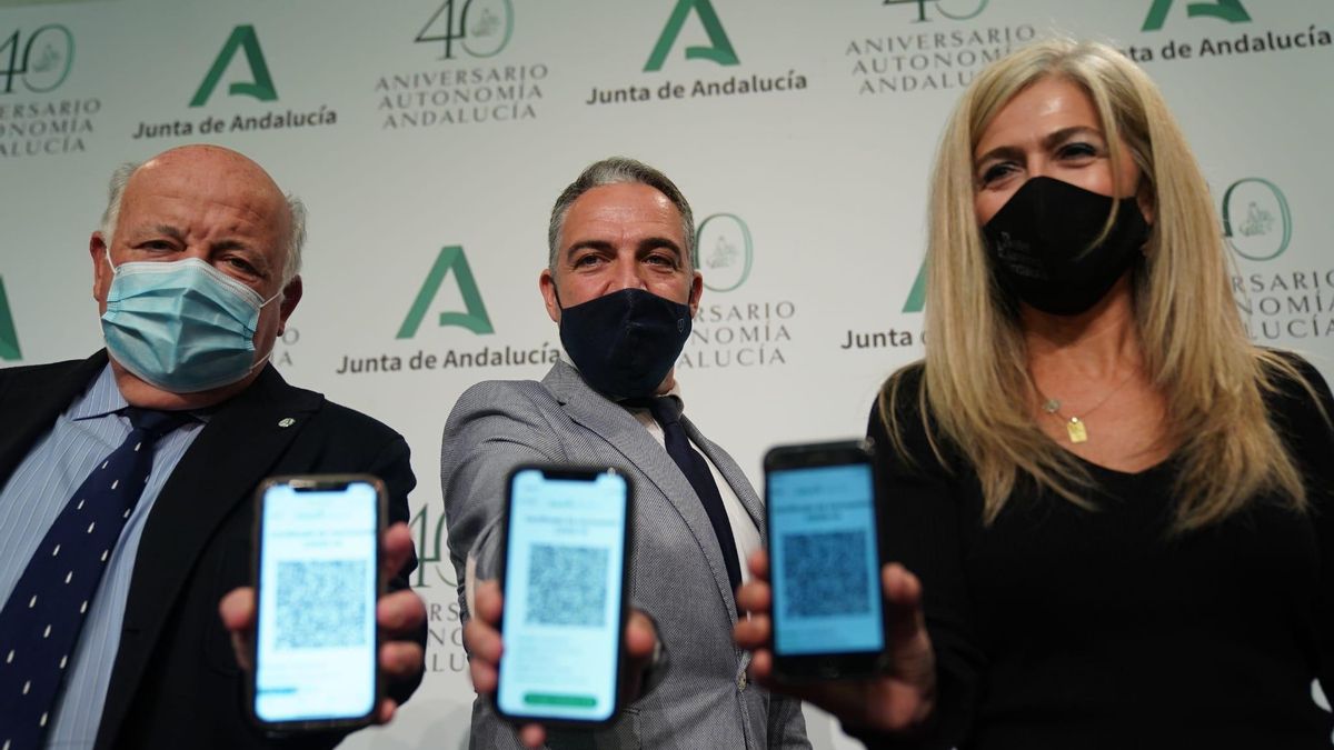 Los consejeros Jesús Aguirre (i.), Elías Bendodo (c.) y Patricia del Pozo, este martes, mostrando el acceso al código QR