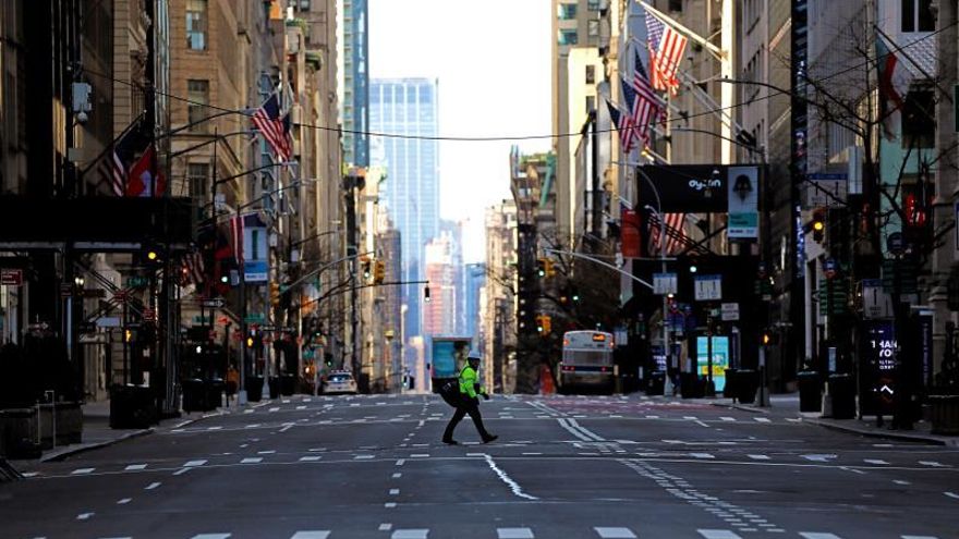 A pedestrian crosses a trafficless Fifth Avenue in New York, New York, USA, 02 April 2020.