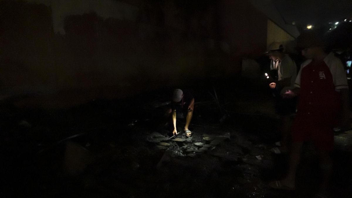 Jóvenes inspeccionan lo que queda de las chabolas, tras el incendio alrededor de las naves del Tarajal, en Ceuta, el 11 de septiembre de 2026.