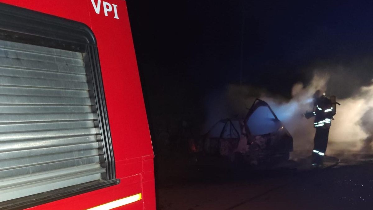 Un bombero en las tareas de extinción del incendio de un vehículo en Barlovento en la madrugada de este domingo.