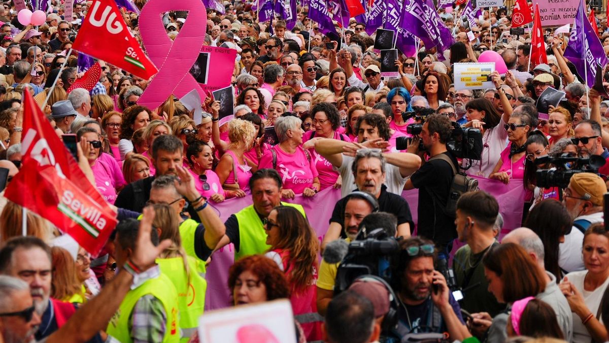 Un gentío rodea a las representantes de Amama con su pancarta.