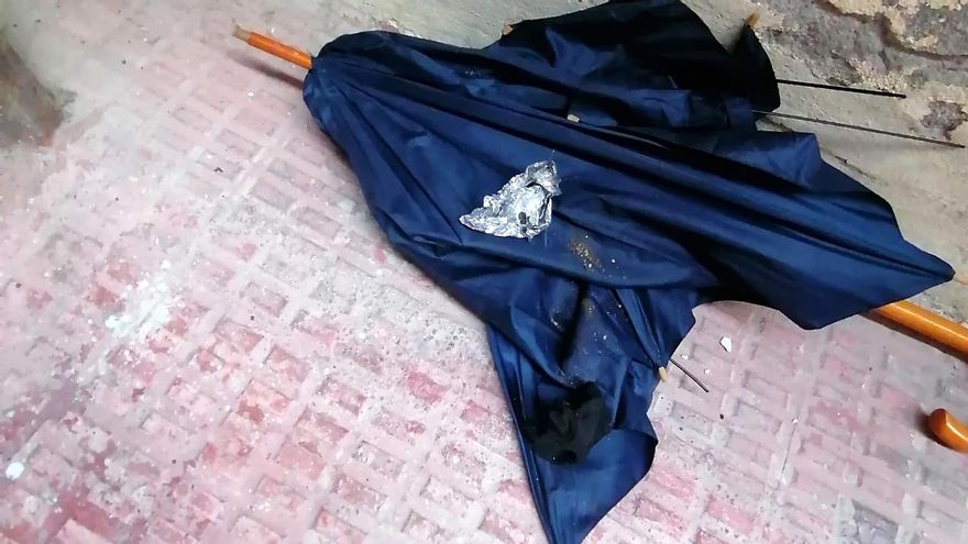 Un paraguas tirado en el patio central de la corrala, sobre el que queda un pedazo de papel de plata arrugado