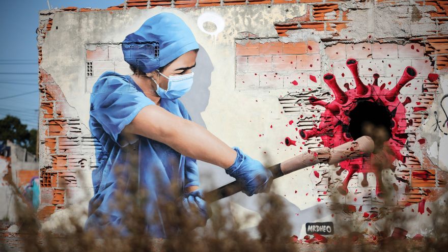 Un grafiti del artista callejero MrDheo representa a una sanitaria golpeando al virus de la Covid-19, en las afueras de Vila Nova de Gaia, en el norte de Portugal. EFE/ Jose Coelho /Archivo