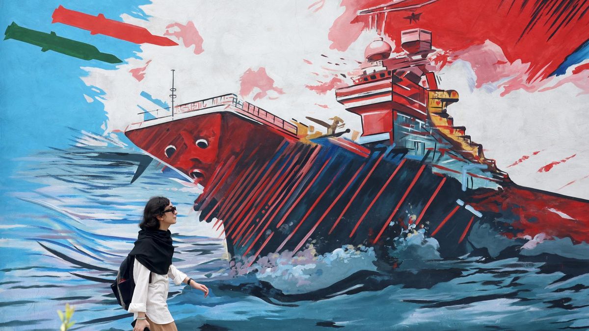 Una mujer camina enfrente de un mural que simboliza el poderío militar iraní en la capital, Teherán, el 20 de julio de 2026.
