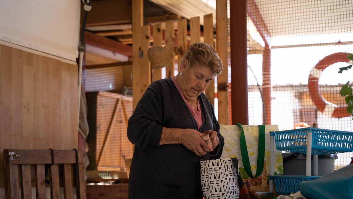 Emilia Peñalver deja las bolsas de la compra en la terraza de la barraca de su hija