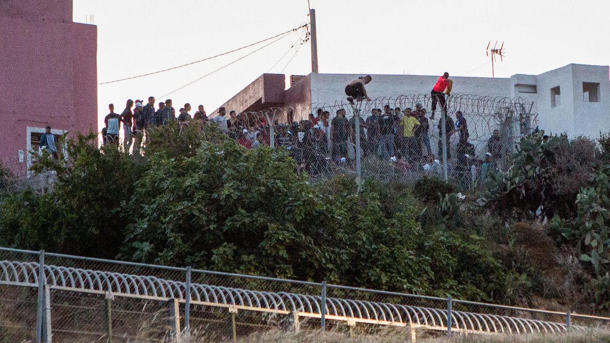 Archivo - Varios marroquíes intentan llegar a suelo español desde la frontera que separa Melilla y Marruecos, a 21 de mayo de 2021.