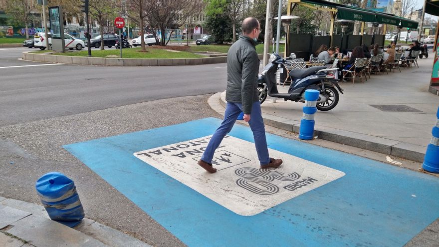 Un peatón cruza en Recoletos el pictograma que avisaba de la calle peatonal, ahora desaparecido