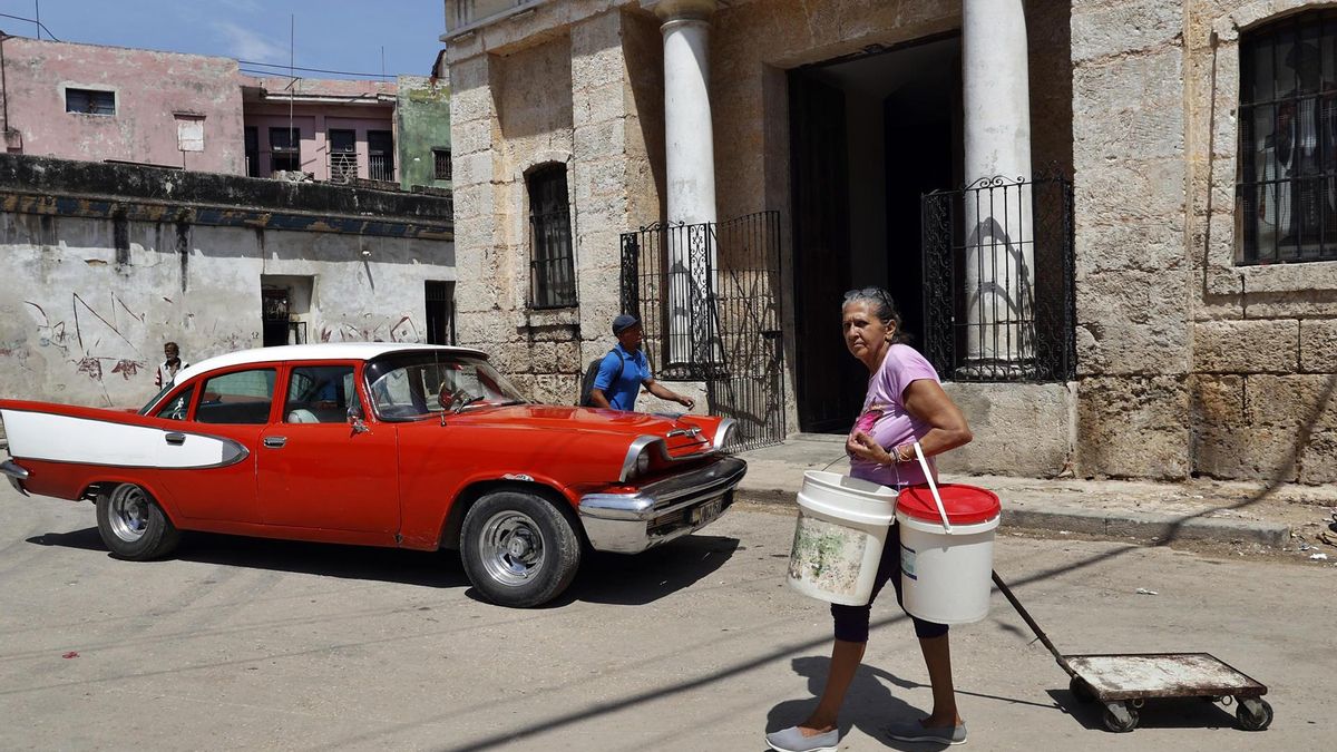 Fotografía del 29 de mayo de 2026 que muestra a una persona caminando con bidones para recoger agua en La Habana (Cuba)