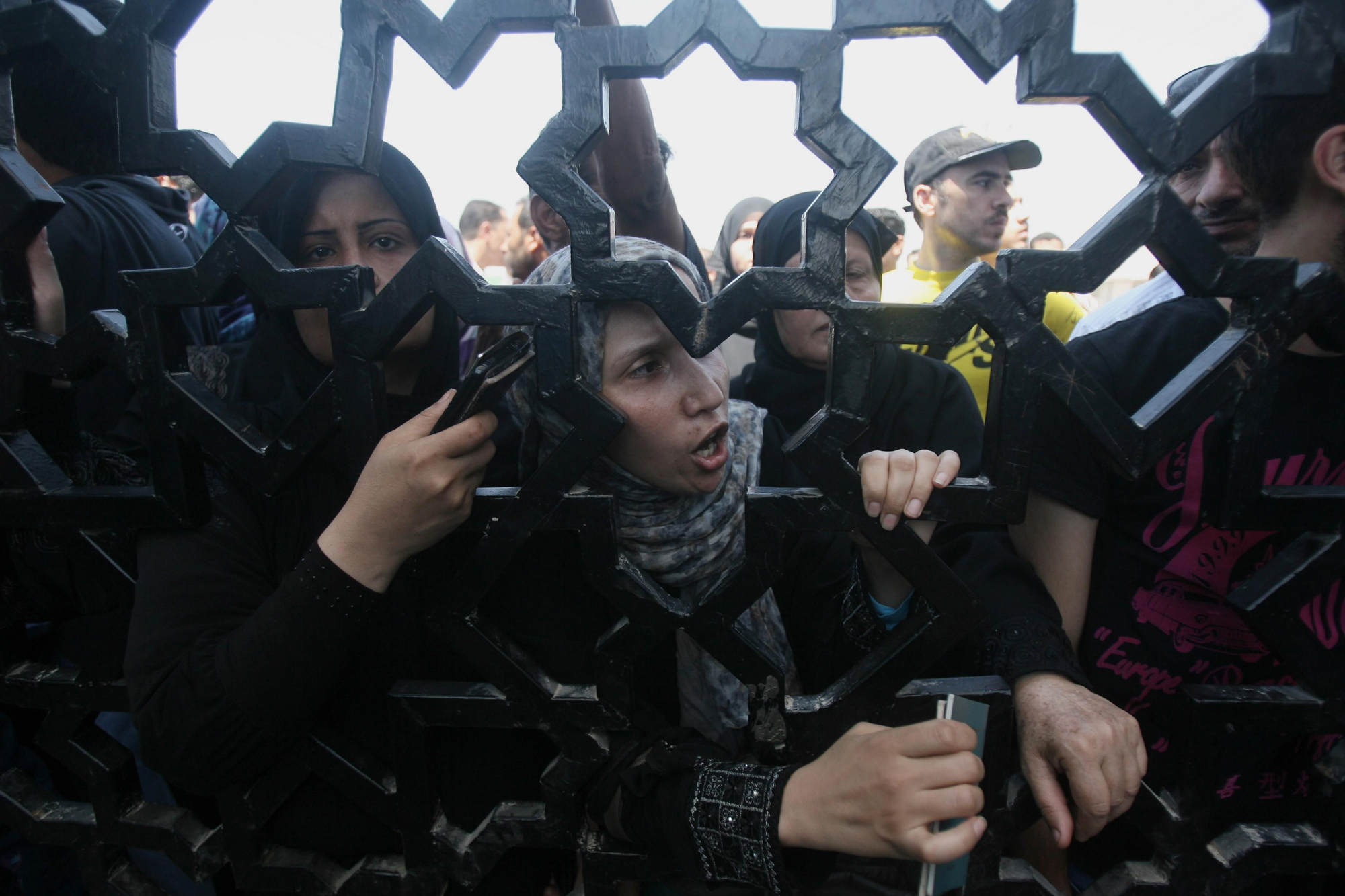 Palestinos con sus pasaportes en la mano intentan atravesar la frontera entre Gaza y Egipto en Rafá el 10 de julio. Foto: Eyad Baba/AP.