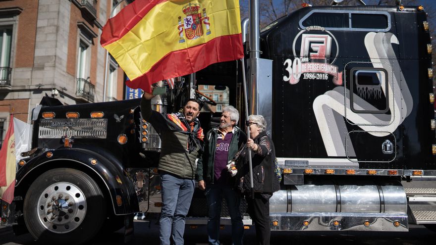 Asistentes a la protesta ondean una bandera de España.