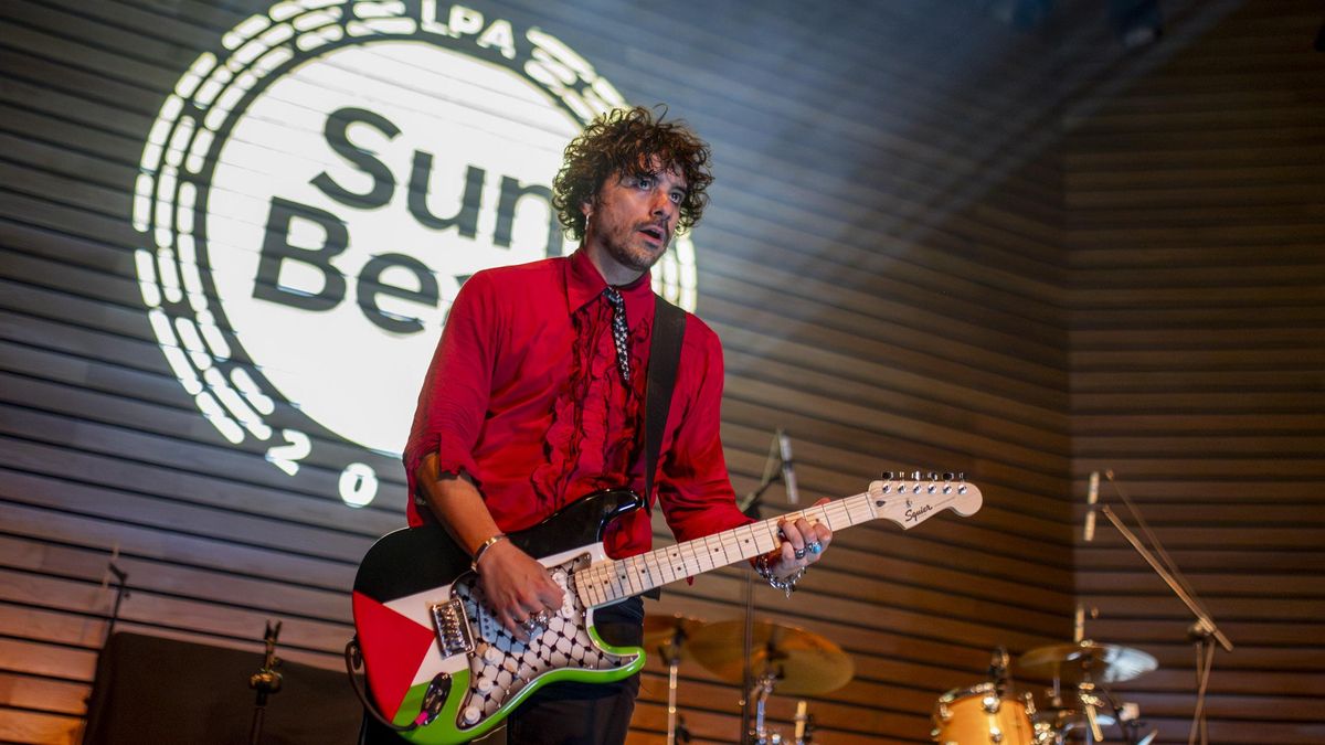 Said Muti sostiene la guitarra, creación de Carmelo Angulo, que lleva representadas la bandera de Palestina y la kufiya, símbolo de resistencia frente al genocidio israelí.