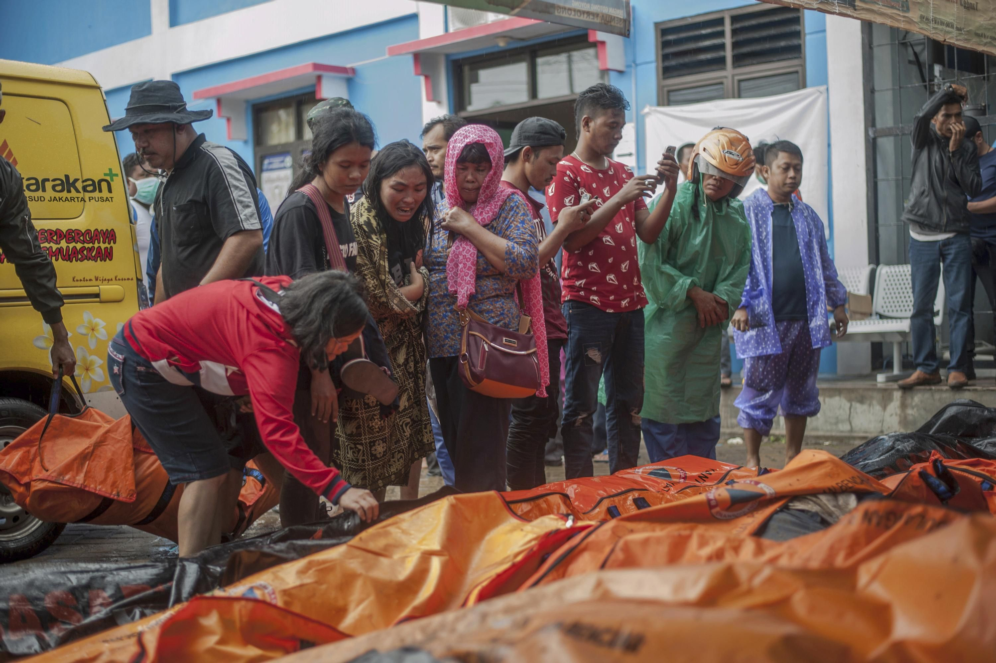 Personas buscan a sus parientes entre los fallecidos en el tsunami de este sábado en Carita, Indonesia