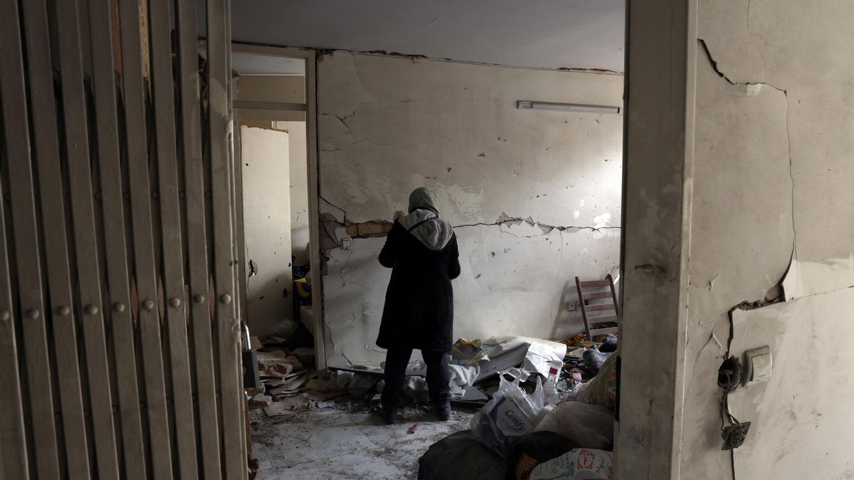 Una mujer iraní busca entre los escombros de su edificio residencial dañado en el centro de Teherán.