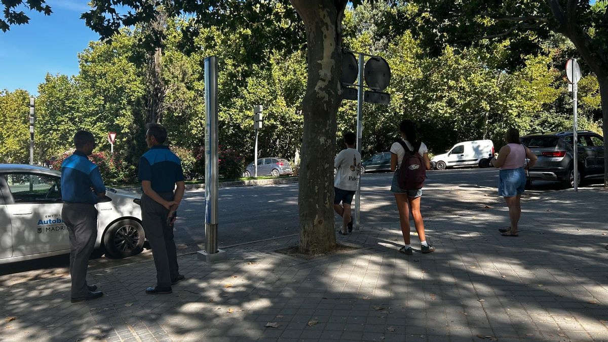 Dos trabajadores de la EMT y varios pasajeros esperan la llegada del autobús autónomo
