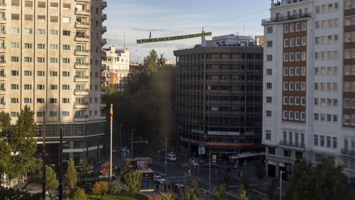 "El planeta, en la cuerda floja": una activista de Greenpeace camina a 30 metros de altura en Madrid para exigir "justicia climática"