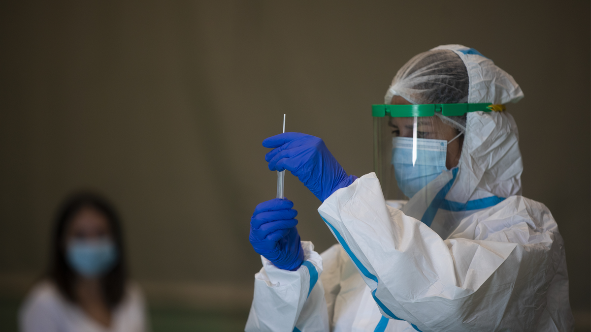 Una sanitaria atiende a una mujer durante las pruebas de cribado de covid-19 con test de antígenos en pabellones deportivos de la ciudad. En Sevilla (Andalucía, España), a 28 de octubre de 2020.