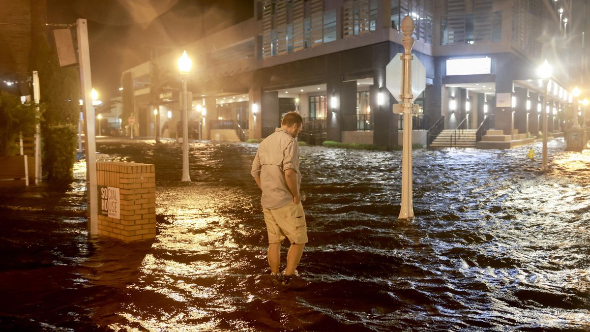 Un hombre camina por las calles inundadas de Fort Myers, Florida, después de que el huracán Milton tocara tierra este miércoles