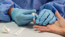 Una enfermera toma muestras de sangre a una mujer para realizarle un test rápido de coronavirus.