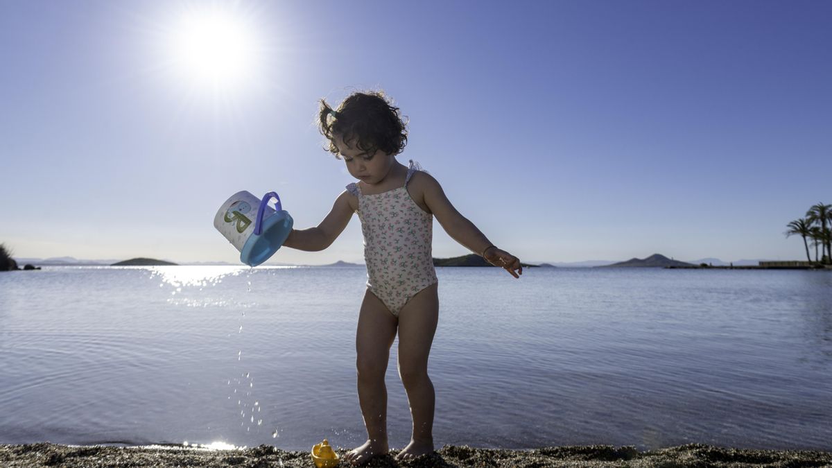Una niña juega a la orilla de una de las playas de la Región