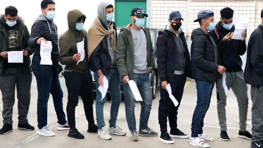 Varios migrantes esperan con su solicitud de readmisión a las puertas del Canarias 50