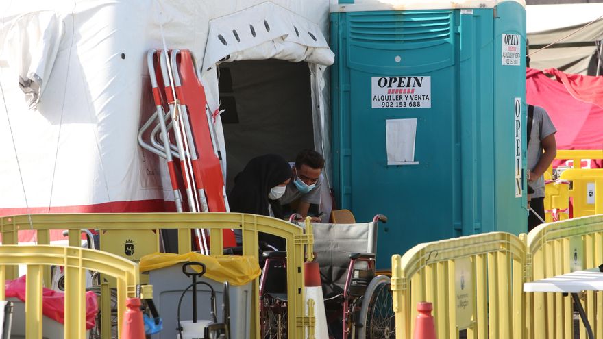 Una mujer y un hombre marroquíes observan un móvil en la enfermería del puerto de Arguineguín días después de llegar a Gran Canaria en patera