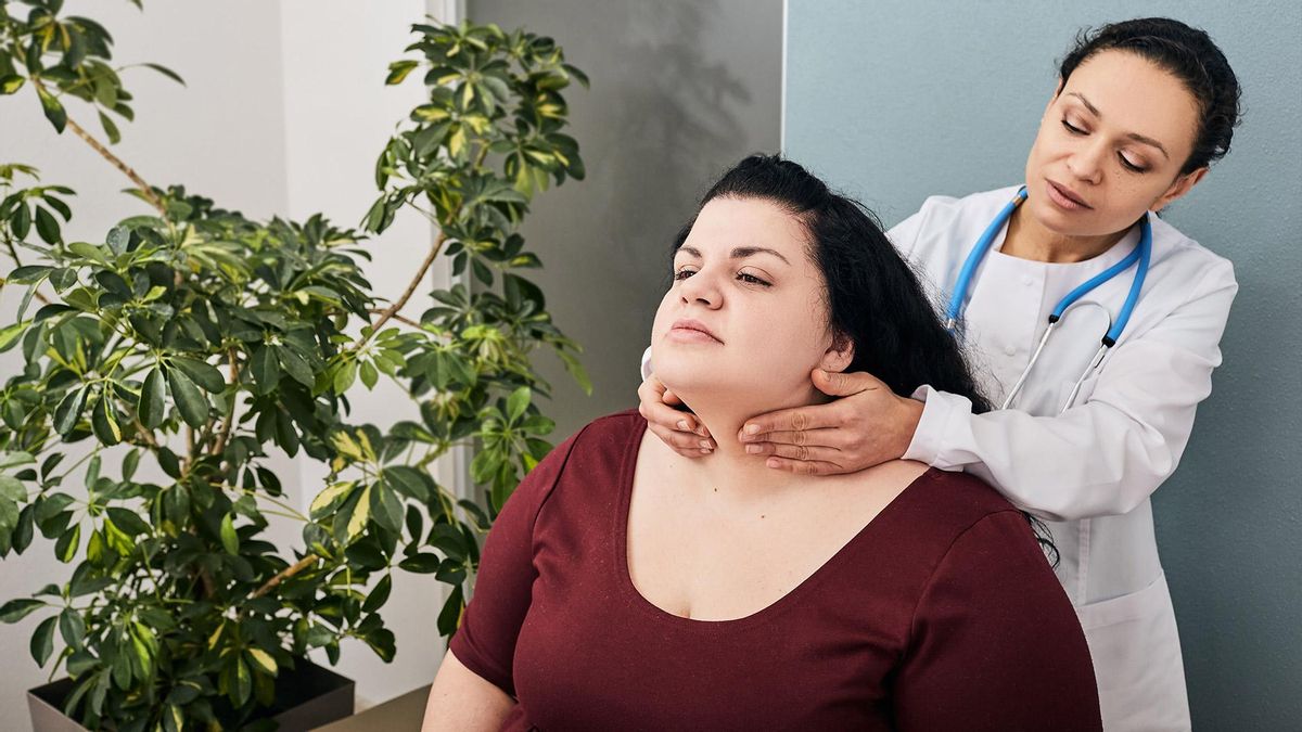 Una endocrina palpando la glándula tiroides en una paciente